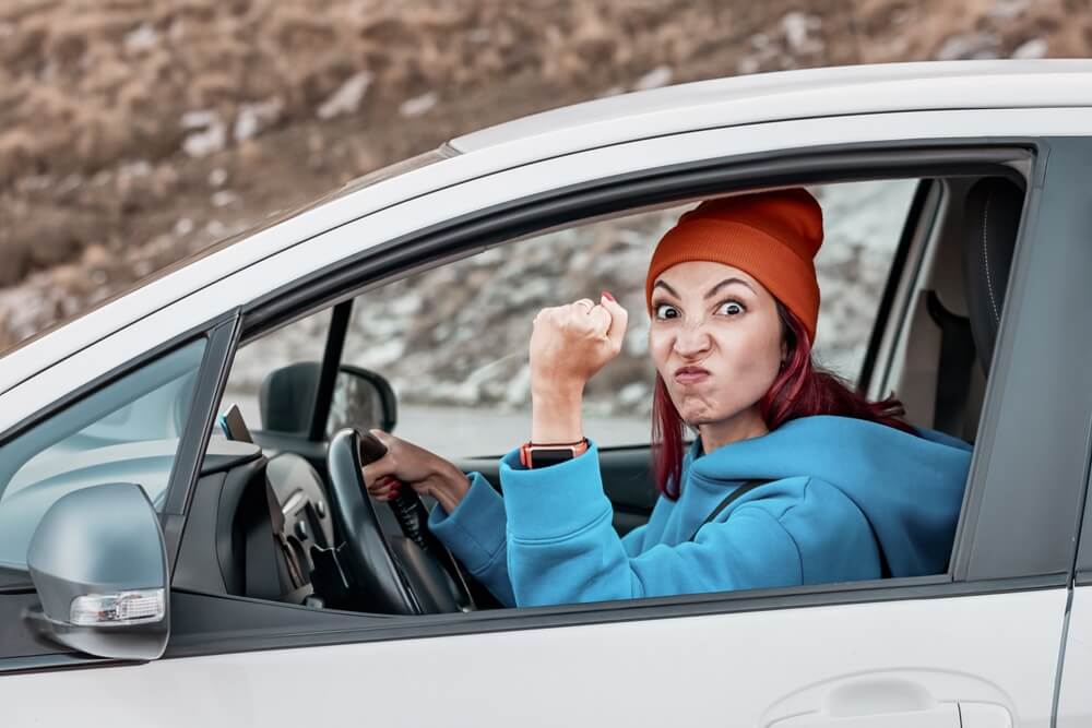 A teenage female driver grumbling at another driver, confident because she has teen driver insurance WA.
