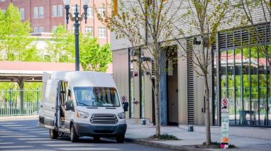 Delivery van in front of building in downtown, commercial auto insurance in Washington needed.