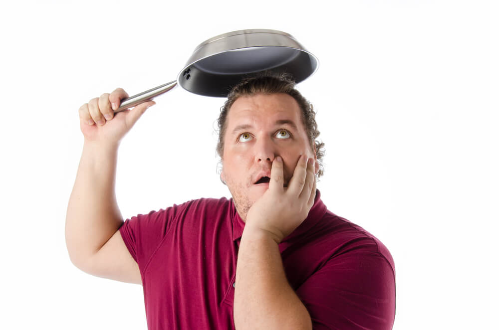 Funny man with a frying pan. Protection against rain and leaky roof in Washington.