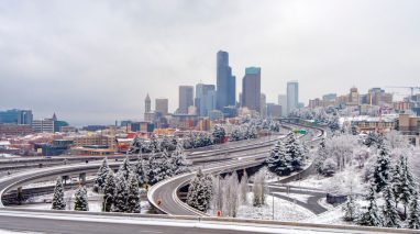 Downtown Seattle is covered in snow on a cloudy winter day, highlighting how harsh weather makes commercial auto insurance essential for businesses on the road