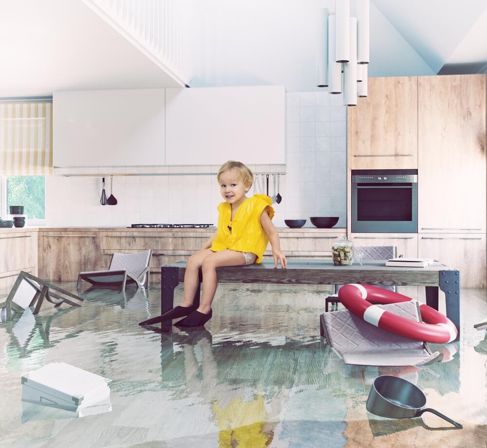 Little girl sitting on top of the counter because there's a flood in her house.