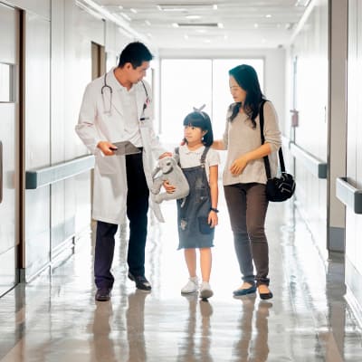 Male doctor talking and walking with a daughter and her mother